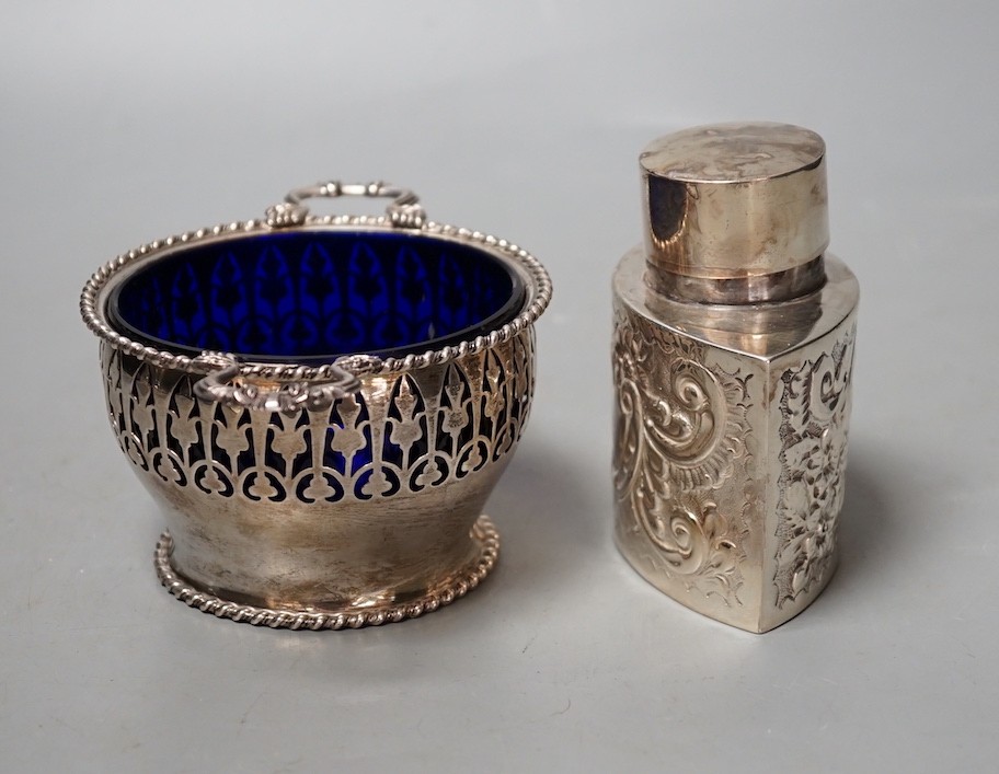 A late Victorian repousse silver tea caddy, Birmingham, 1899, height, 86mm and a later silver two handled sugar bowl with blue glass liner.